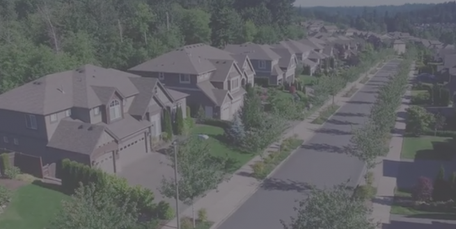 Aerial photo of a wooded subdivision of houses.
