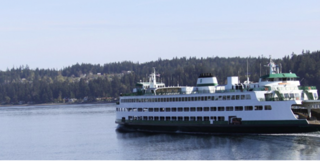 Ferry moving through calm waters with a forest in the background.