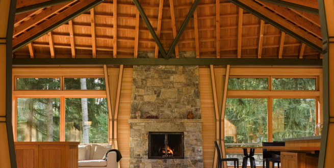 Interior photo of timber framed home with a stone fireplace.