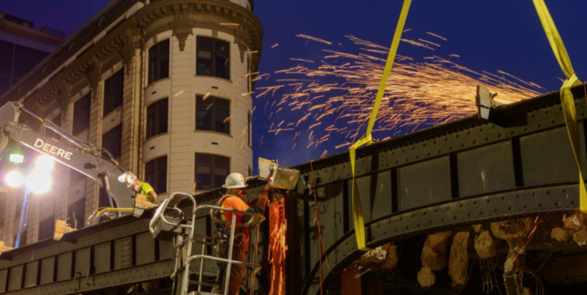 Construction workers working on a steel bridge.