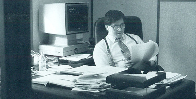 old photo of a copy editor at a newspaper, reviewing papers