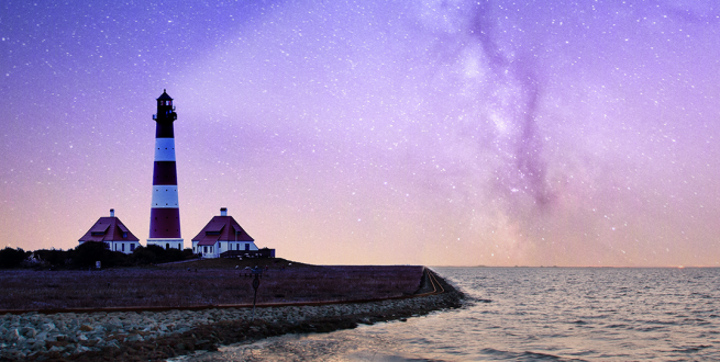Lighthouse shining into the night sky