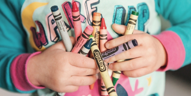 child holding crayons